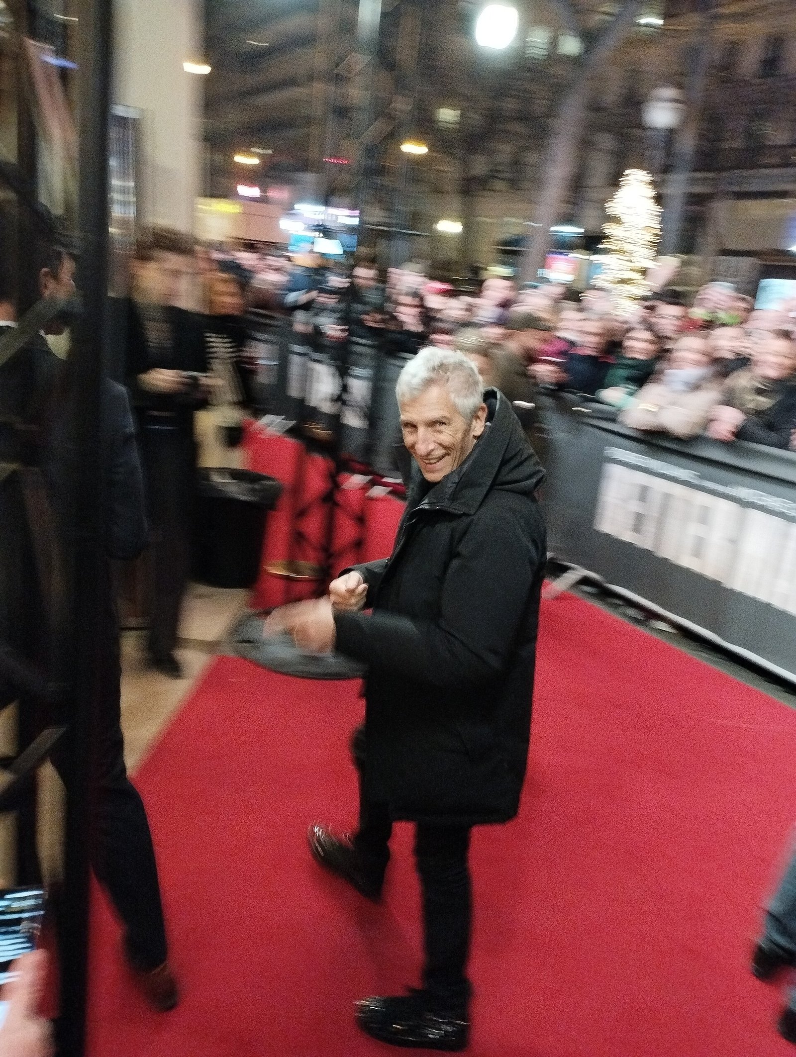 Nagui souriant salue le public sur un tapis rouge