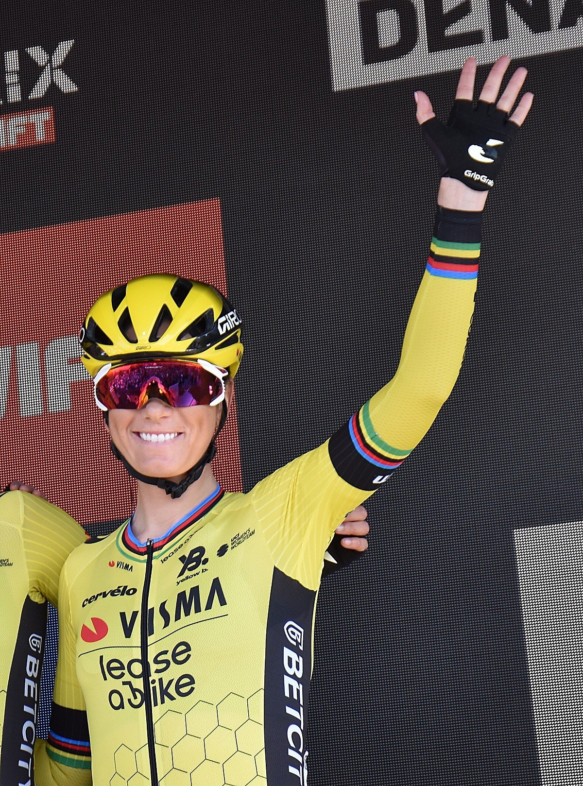 Pauline Ferrand-Prévot en maillot jaune, souriante sur un podium