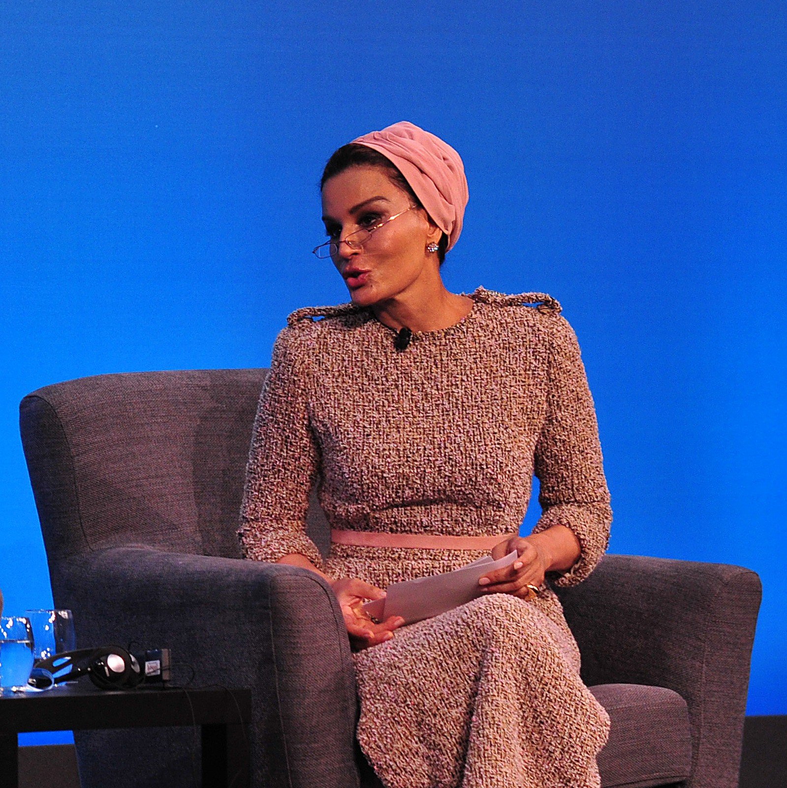 Portrait de Sheikha Moza bint Nasser du Qatar, turban rose et lunettes, lors d'un sommet sur l'éducation