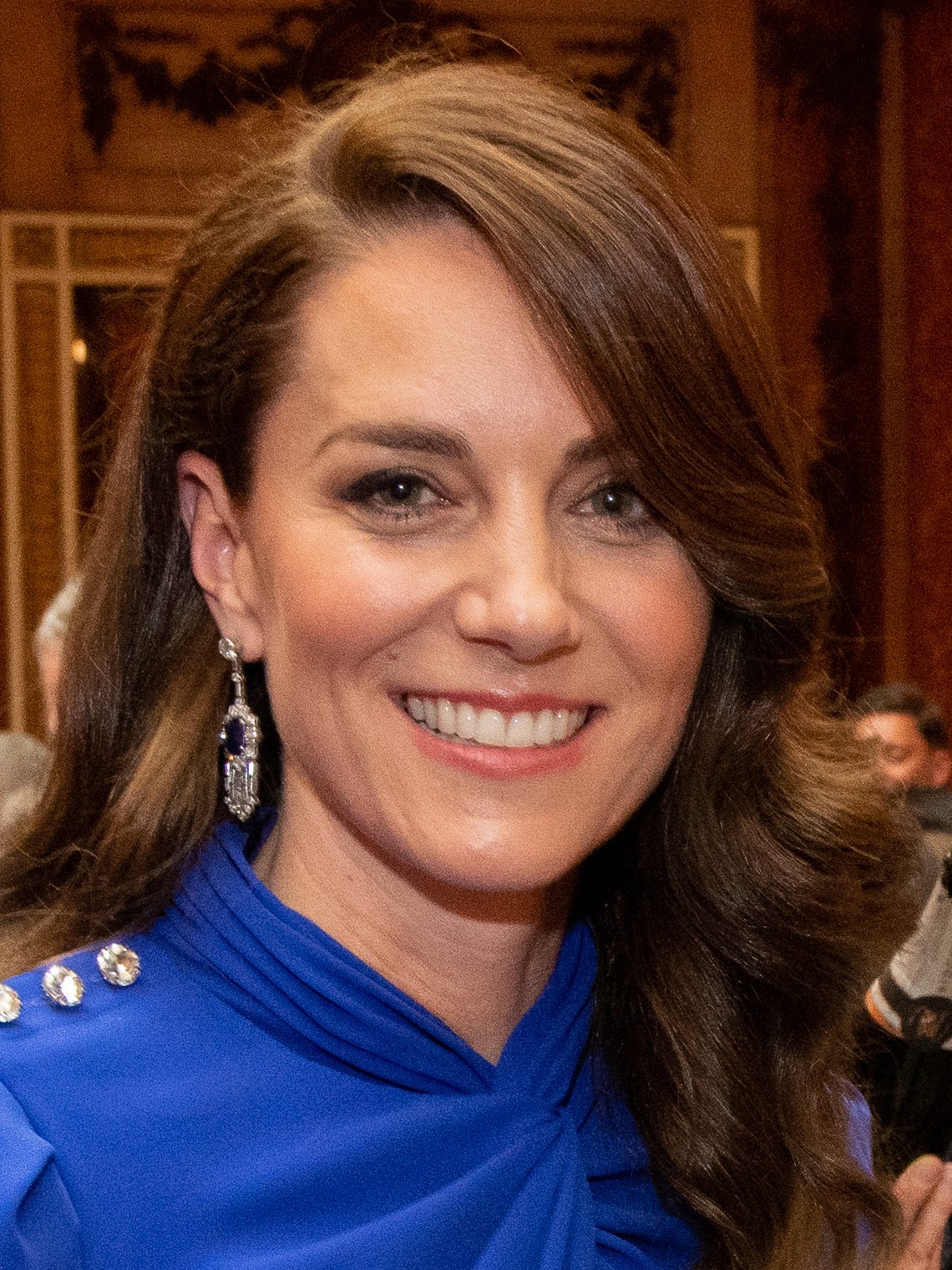 Portrait de la princesse Catherine de Galles, souriante, robe bleue
