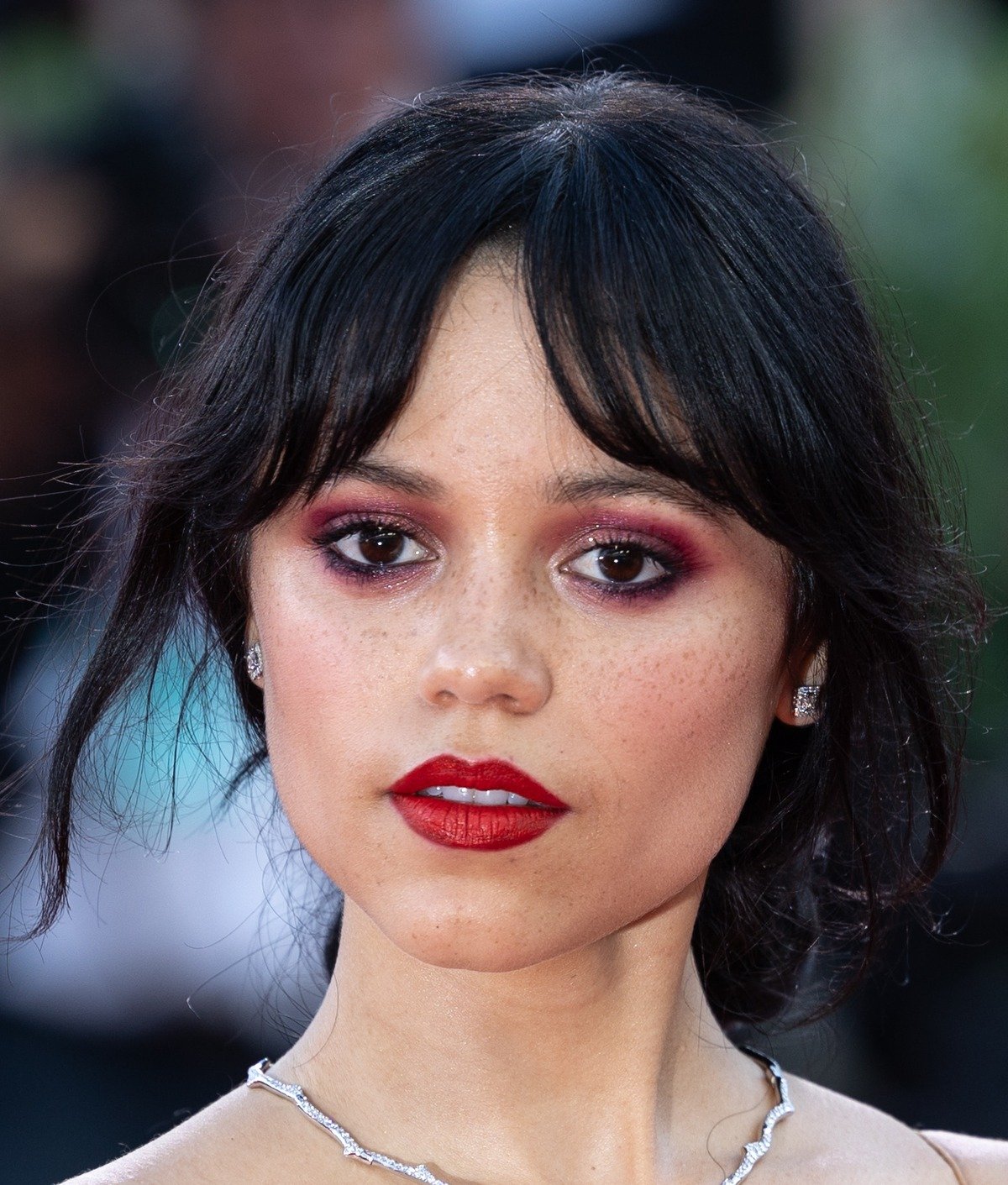 L'actrice américaine Jenna Ortega, en robe rouge, sur un tapis rouge de festival
