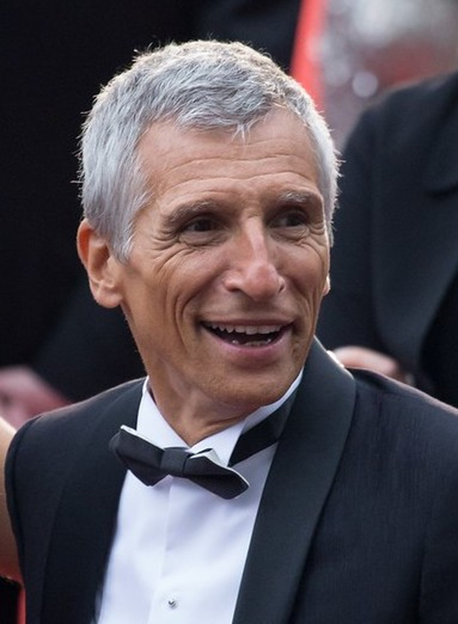 Nagui, animateur de télévision français, souriant sur un tapis rouge