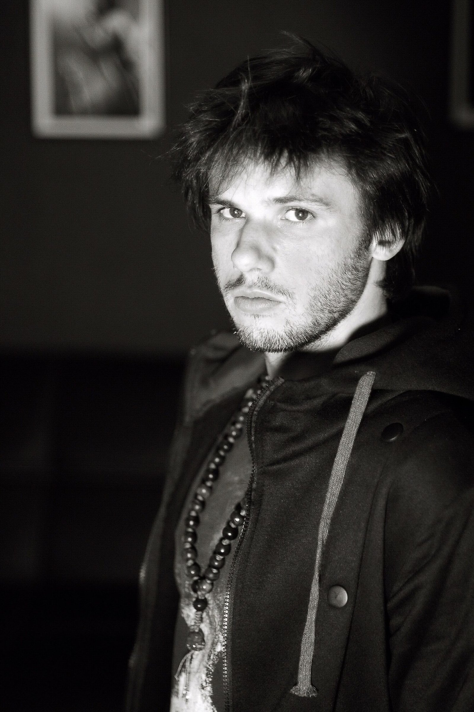 Portrait en noir et blanc du rappeur français Orelsan, regard face caméra
