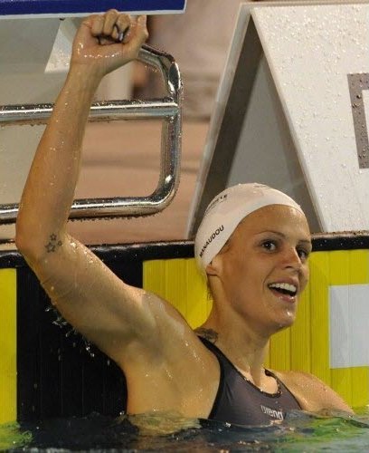 Laure Manaudou, nageuse, levant le bras après une victoire